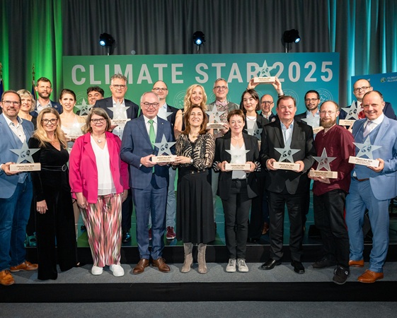 Group photo of 16 Climate Star Award winners holding their Awards