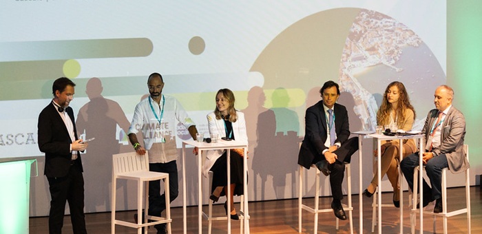 Six people sitting on stage for a plenary discussion